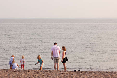 Rodby, Denmark - July 19, 2019: family playing by the sea in the eveningのeditorial素材