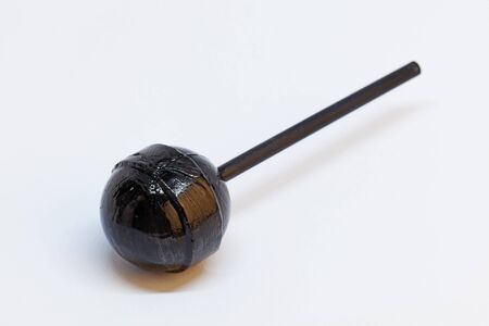 black licorice lollipop on white backgroundの写真素材