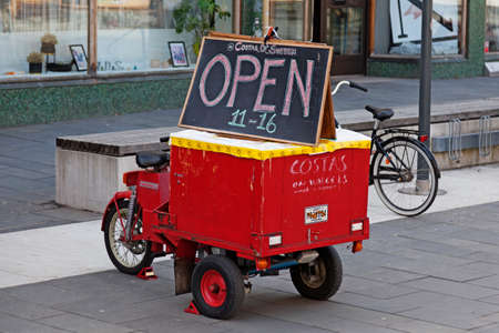 Umea, Norrland Sweden - April 6, 2020: Old red three wheel moped with sign for restaurantのeditorial素材