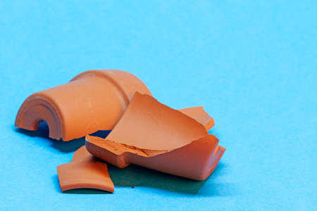 a broken flower pot on blue backgroundの写真素材