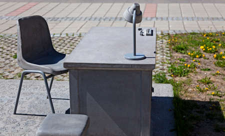 Umea, Norrland Sweden - June 8, 2020: desk and lamp in concrete as a work of art outdoors