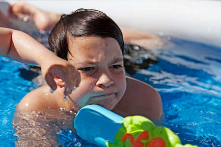 Umea, Norrland Sweden - June 6, 2020: a guy in the swimming pool with a mission and a water gunのeditorial素材