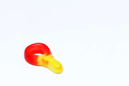 a red and yellow candy pacifier on white background