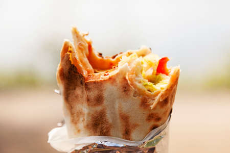 a roll pizza with vegetables that someone took a few pieces fromの写真素材