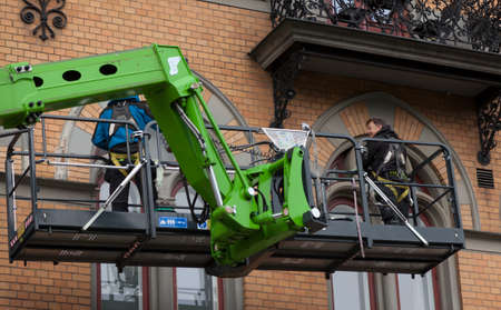 Sundsvall, Norrland Sweden - July 15, 2020: two men working on cleaning windows from a crane truck