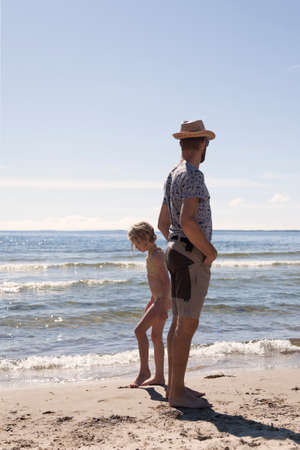 Umea, Norrland Sweden - July 16, 2020: father and daughter at the beach edgeのeditorial素材