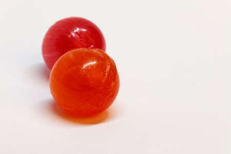 hard red and orange candies on white backgroundの写真素材