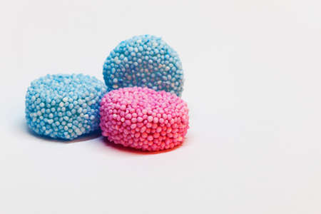 two light blue and a pink piece of candy with sprinkles on
