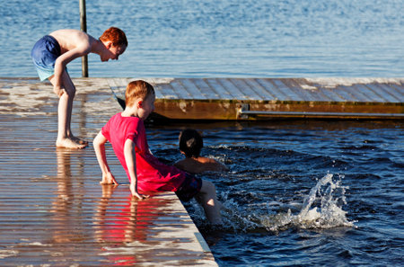 Umea, Norrland Sweden - June 7, 2020: children playing on a bathing jetty togetherのeditorial素材