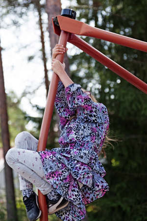 Umea, Norrland Sweden - June 7, 2019: little girl climbs in device at playground