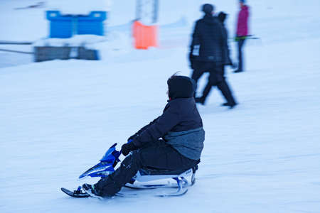 Umea, Norrland Sweden - February 8, 2021: a little boy slides down the ski slopeのeditorial素材