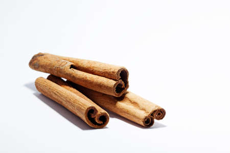 cinnamon sticks lying on white backgroundの写真素材