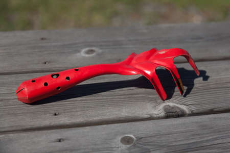 a red cultivator lies on the table, used in gardeningの写真素材