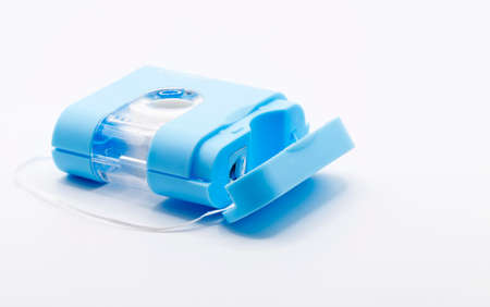 a roller with dental floss on white backgroundの写真素材