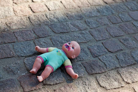 creepy and nasty doll lying on the groundの写真素材