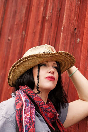 Umea, Norrland Sweden - August 22, 2021: beautiful woman with hat by red wooden buildingのeditorial素材