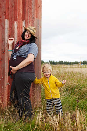 Umea, Norrland Sweden - August 22, 2021: pregnant mother and son playing in meadowのeditorial素材