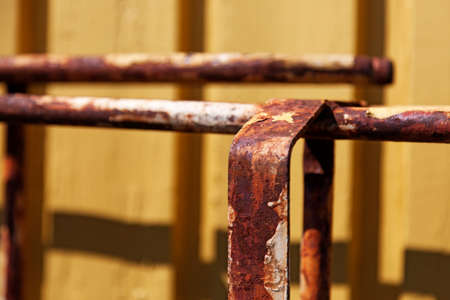 holder for rusty pipes against yellow background