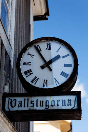 Nordmaling, Norrland Sweden - July 21, 2021: old clock and sign with the text: - meadow cottagesのeditorial素材