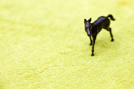 black toy horse in plastic on green backgroundの写真素材
