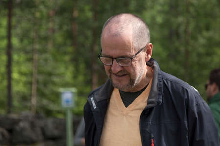 Umea, Norrland Sweden - July 16, 2019: elderly man with glasses looking at something on the groundのeditorial素材