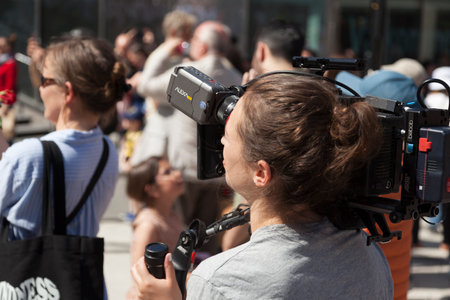 Stockholm, Sweden - May 24, 2023: female cinematographer in public gathering
