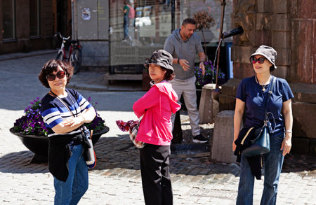 Stockholm, Sweden - May 24, 2023: three Japanese people posing by fountain in old townのeditorial素材