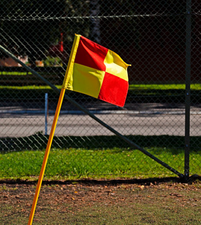 leaning corner flag on a football field red and yellowの写真素材