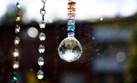 Prism and crystals hang in the window and create rainbow colorsの写真素材