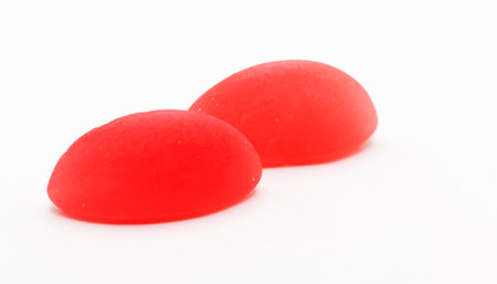 Two glossy red boat gummy candies positioned side by side, embodying sweet romance and simplicity.の写真素材