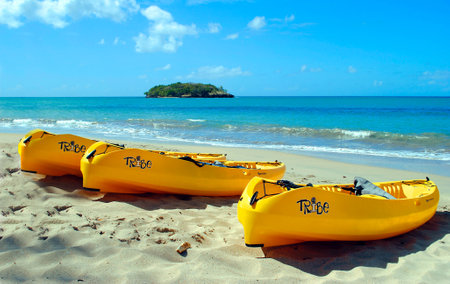 Halcyon Beach in St Lucia in the eastern Caribbean Sea, Part of the Lesser Antilles  JANUARY 28 2012  Three canoes on the silver white sand beach for a tropical vacation at Sandals Luxury Hotelのeditorial素材