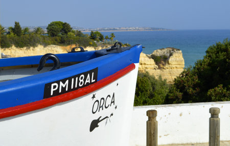 Colourful Fishing Boat on Senhora Da Rocha Beach in Portugalのeditorial素材