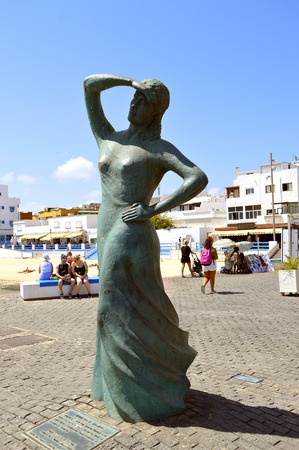 Statue of a lady looking out to sea in Corralejo harbourの写真素材