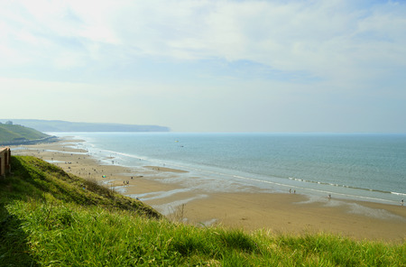 Tourists on Whitby beach West Cliff in North Yorkshireの写真素材