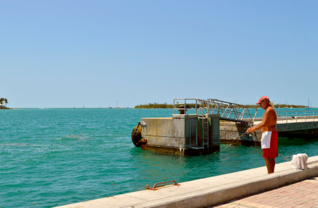 Key West Florida Keys Florida USA - May 15 2017 : Man fishing in Key West Marinaのeditorial素材