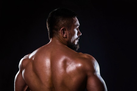 Muscular male back with lights showing muscle detail isolatedの写真素材