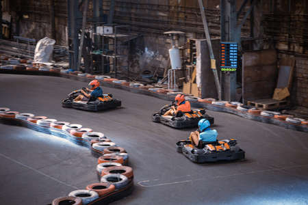 Three guys racing with go karts indoors