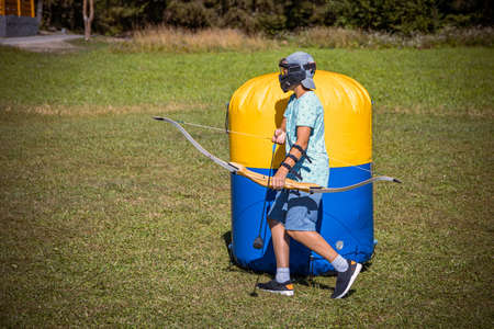 Young boy preparing to shoot arrow during a game of archery tagの写真素材