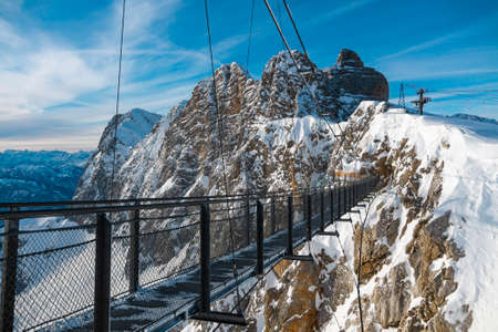 Suspended bridge over a snowy valley on the Dachstein glacier in Alps in Austriaの写真素材