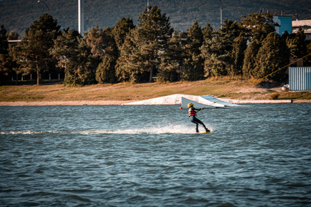 Child being pulled on a wakeboard on a lakeの写真素材