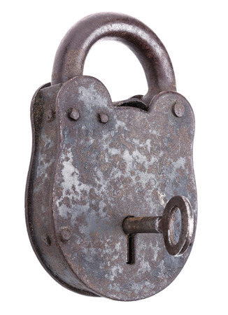 Locked medieval padlock with key, made of iron and slightly rusty. Portable lock with a shackle that may be passed through an opening to protect against unauthorized use, theft, vandalism or harm.の写真素材