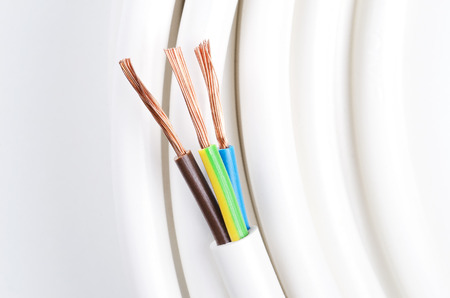 Electrical cable with three insulated conductors. Power cable cross-section. Cable jacket with wire insulation and flexible stranded copper wires. IEC standard color code. Macro photo from avove.の写真素材