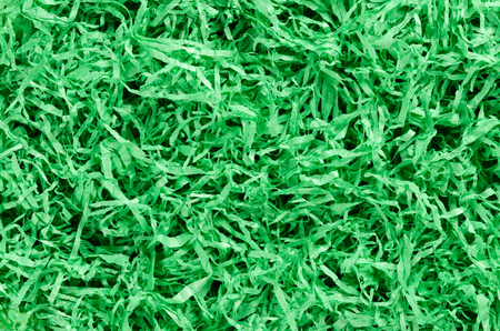 Green paper Easter grass background from above. Colored crinkle grass. Gift basket shred and filler. Decoration.の写真素材