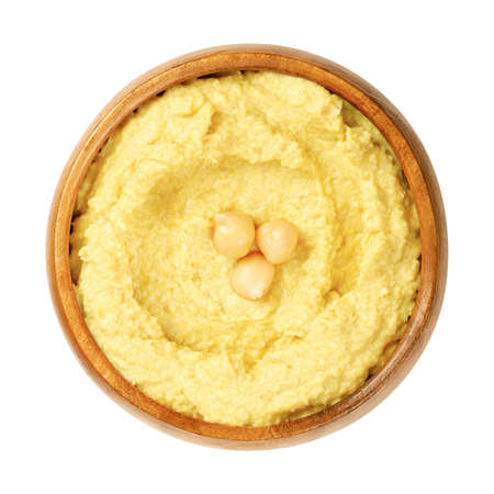 Curry hummus dip with chickpea garnish, in a wooden bowl. Middle Eastern dip, spread or savory dish made of cooked, mashed chickpeas, blended with curry powder, tahini, lemon juice and garlic. Photo.の写真素材