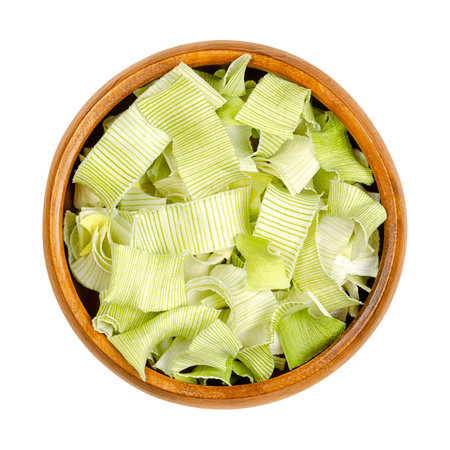 Dehydrated leek flakes, from above, in a wooden bowl. Dried strips of Allium porrum, a slightly green, crunchy and firm vegetable, with aromatic, mild and onion-like taste.の写真素材