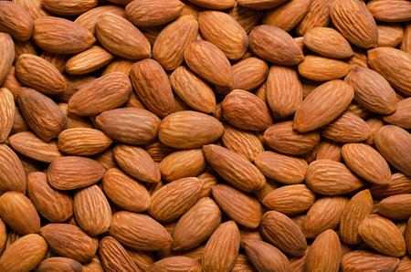Shelled almonds, background from above. Raw, edible and whole dried nuts, botanically drupes, seeds...
