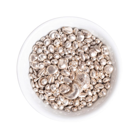 Fine silver granules, in a white bowl, from above.  Granular purified silver, as it comes out of the melt, used and further processed in technology and industry.の写真素材