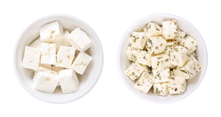 Greek feta cubes, brined cheese, in white bowls. Cheese, matured in brine, with moist texture, and fresh, salty, acidic taste, cut into cubes. Pure (left), and with herbs (right).の写真素材