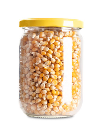 Unpopped popcorn in a glass jar with screw cap. Yellow seeds of a type of corn that expands from the kernel and puffs up when heated. Edible, raw, organic and vegan.の写真素材