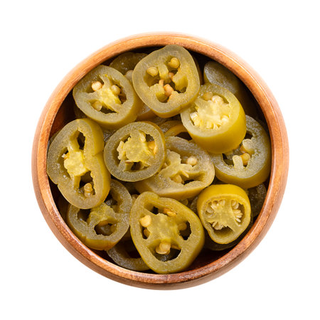 Pickled green jalapeno slices in a wooden bowl. Medium-sized hot, green chili peppers, cut into cross sections, pasteurized and preserved in a salted vinegar brine.の写真素材